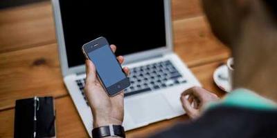Person looking at mobile and laptop